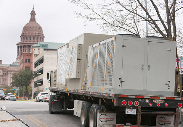 unit strapped on back of transport truck to Travis County Executive Office Building