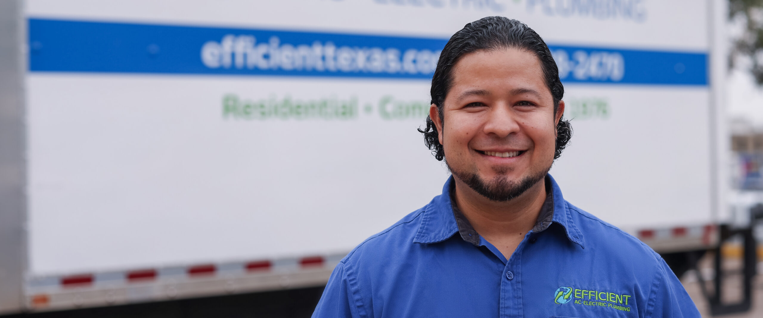 austin furnace maintenance technician standing in front of company trailer